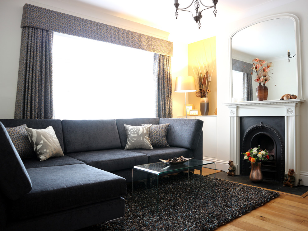 Aménagement d'un salon moderne de taille moyenne et fermé avec un mur blanc, parquet clair, une cheminée standard, un manteau de cheminée en pierre et un sol jaune.