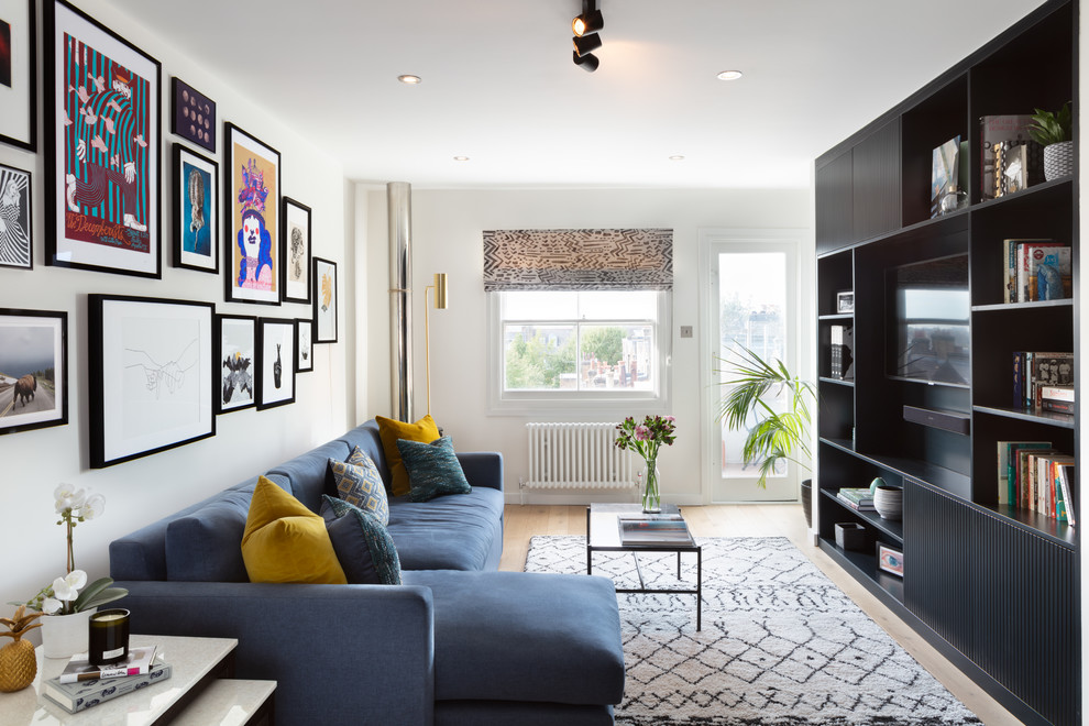 Ispirazione per un soggiorno design con pareti bianche, parquet chiaro, parete attrezzata e pavimento beige