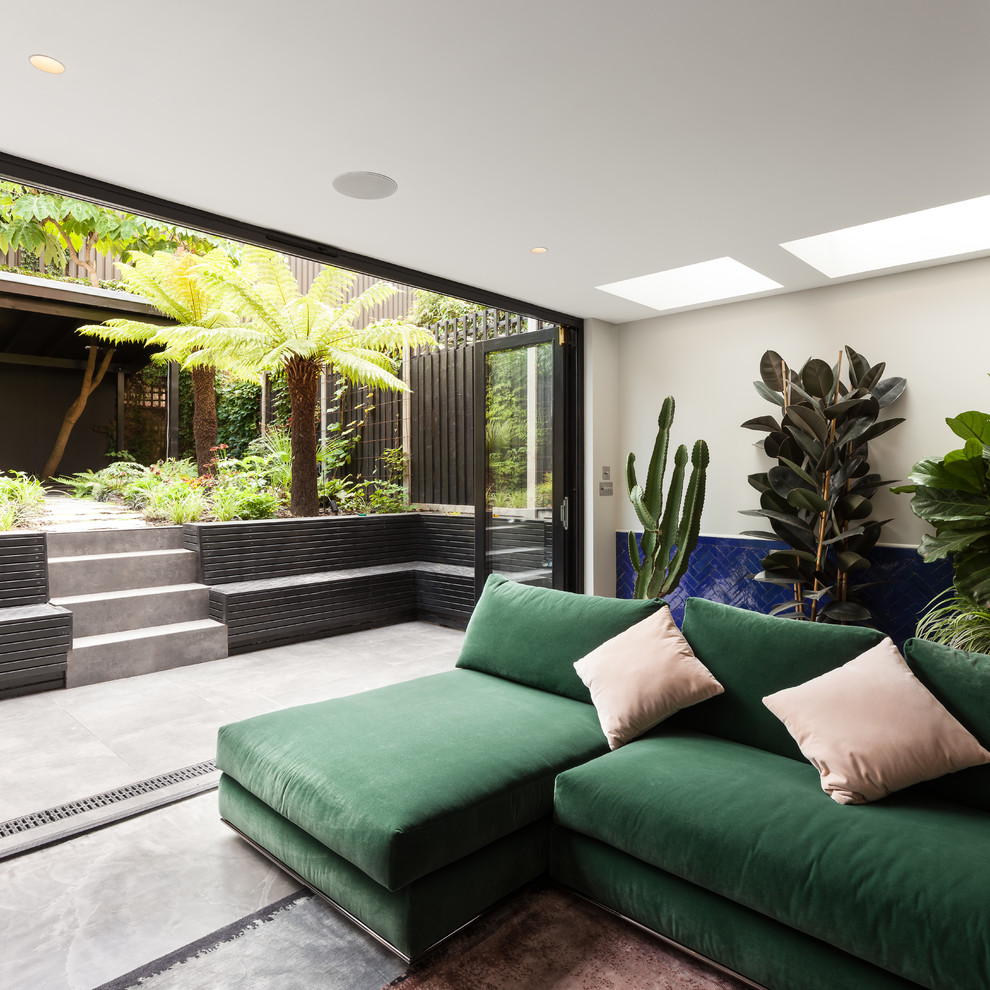 Idee per un soggiorno minimal di medie dimensioni e aperto con pareti grigie, pavimento in cemento, TV a parete e pavimento grigio
