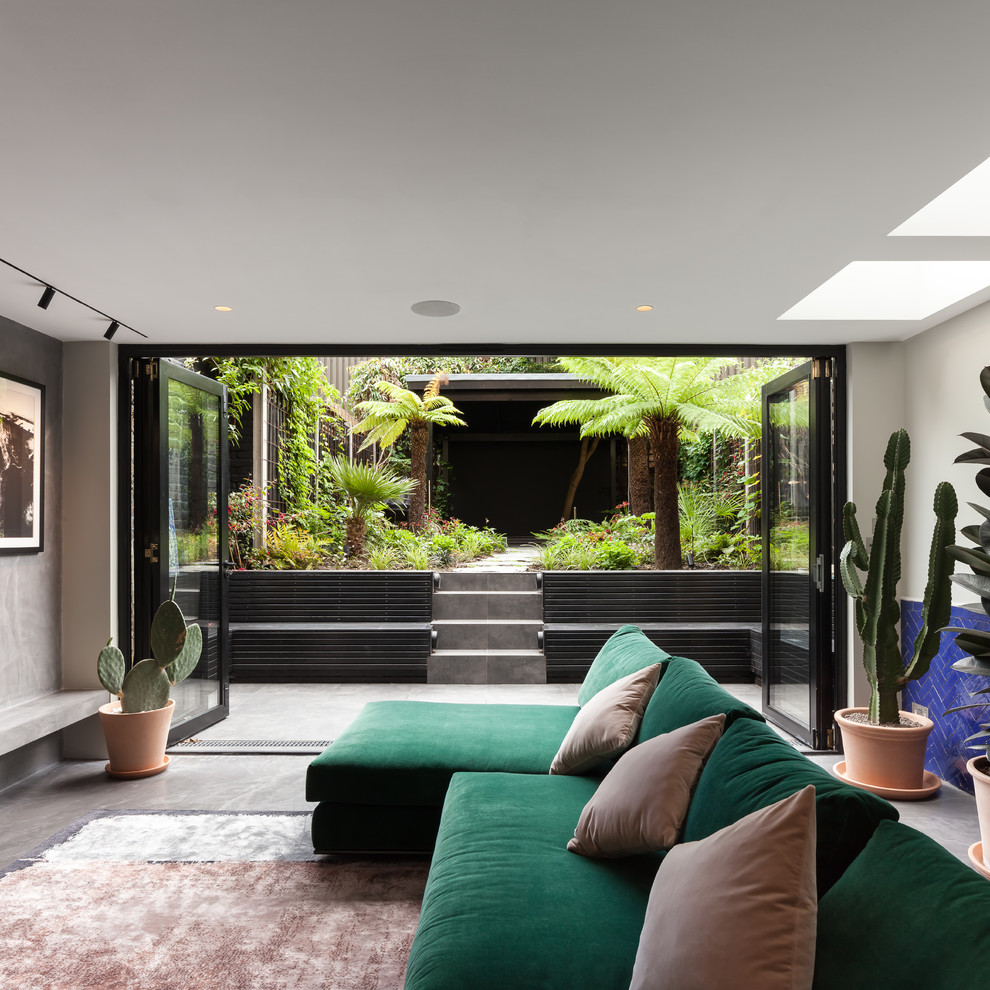 Идея дизайна: открытая гостиная комната среднего размера в современном стиле с серыми стенами, бетонным полом, телевизором на стене и серым полом