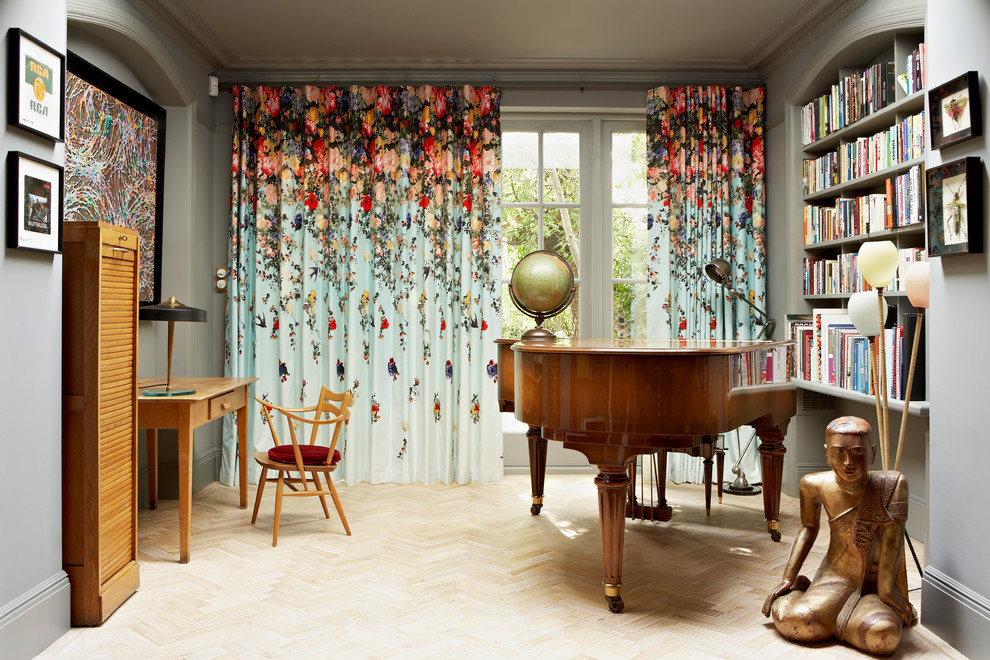Inspiration for an eclectic enclosed living room curtain in London with a music area, grey walls, light hardwood flooring and no tv.