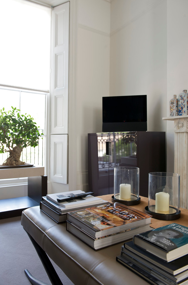 This is an example of a medium sized contemporary enclosed living room in London with white walls, carpet, a standard fireplace, a stone fireplace surround and a freestanding tv.
