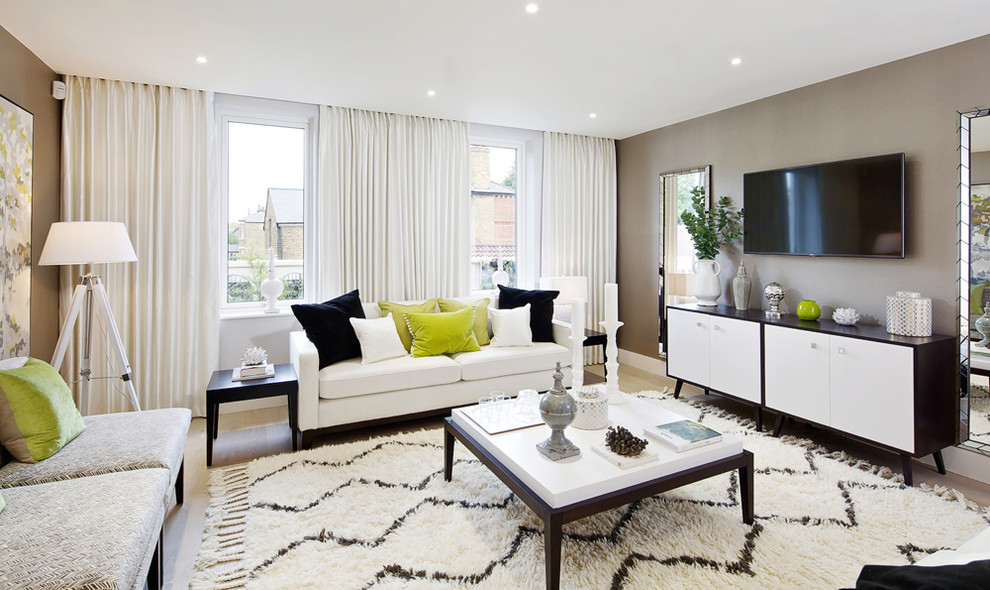 Idee per un soggiorno design con pareti marroni, parquet chiaro e TV a parete