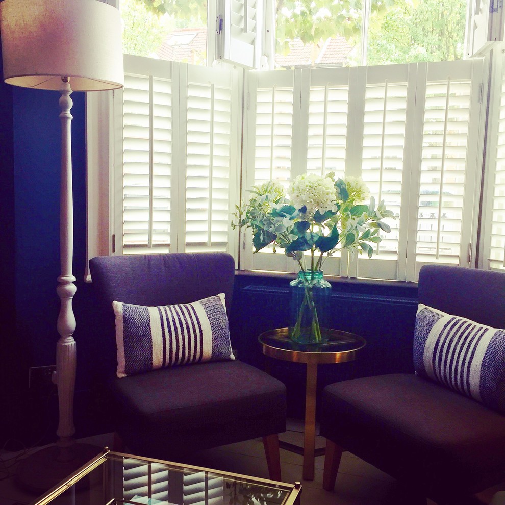 Foto di un piccolo soggiorno design chiuso con pareti blu, pavimento in legno verniciato, camino classico, cornice del camino in legno e pavimento bianco