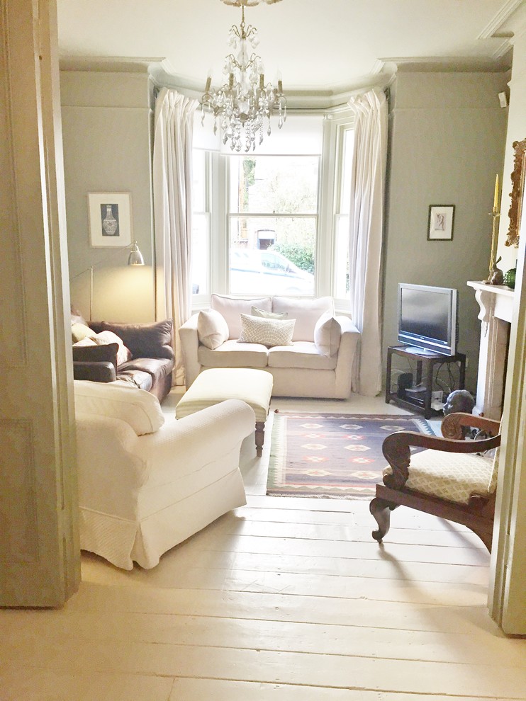 Пример оригинального дизайна: открытая гостиная комната среднего размера в стиле шебби-шик с серыми стенами, деревянным полом, стандартным камином, фасадом камина из камня и отдельно стоящим телевизором