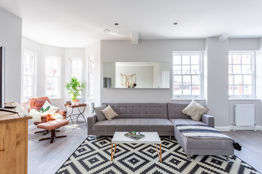 Modernes Wohnzimmer mit grauer Wandfarbe und freistehendem TV in London