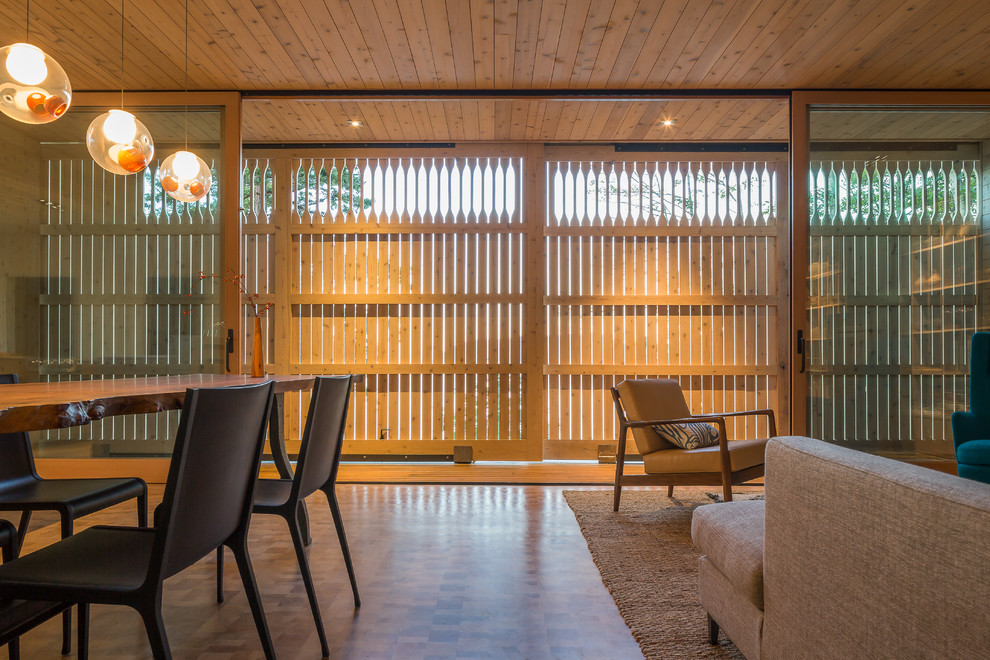 Foto di un soggiorno moderno di medie dimensioni e aperto con libreria, pareti beige e pavimento in legno massello medio