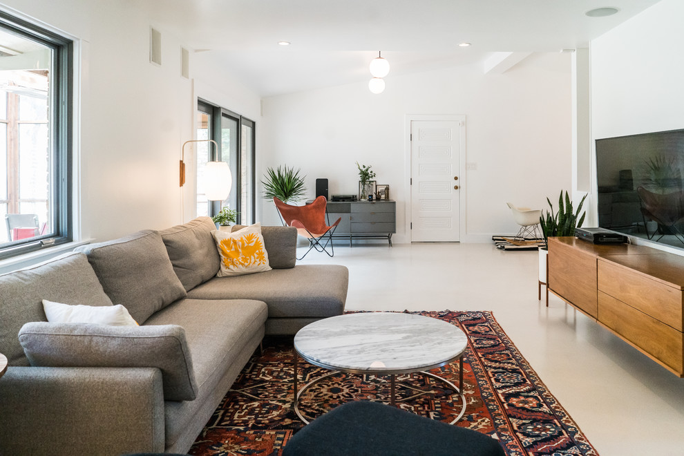 Idéer för att renovera ett mellanstort minimalistiskt separat vardagsrum, med vita väggar, en väggmonterad TV, betonggolv och beiget golv