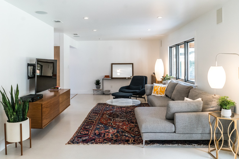 Mittelgroßes, Abgetrenntes Skandinavisches Wohnzimmer mit weißer Wandfarbe, Betonboden, TV-Wand und beigem Boden in Austin