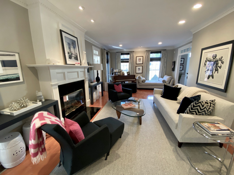 Photo of a medium sized traditional enclosed living room in Boston with grey walls, medium hardwood flooring, a two-sided fireplace, a stone fireplace surround, no tv and brown floors.