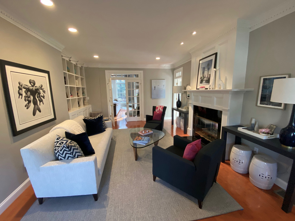 Medium sized traditional enclosed living room in Boston with grey walls, medium hardwood flooring, a two-sided fireplace, a stone fireplace surround, no tv and brown floors.