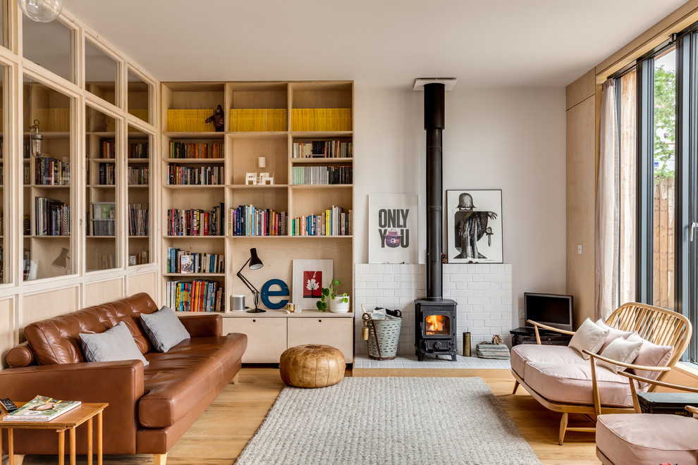 Imagen de salón abierto escandinavo de tamaño medio con paredes blancas, suelo de madera clara y estufa de leña