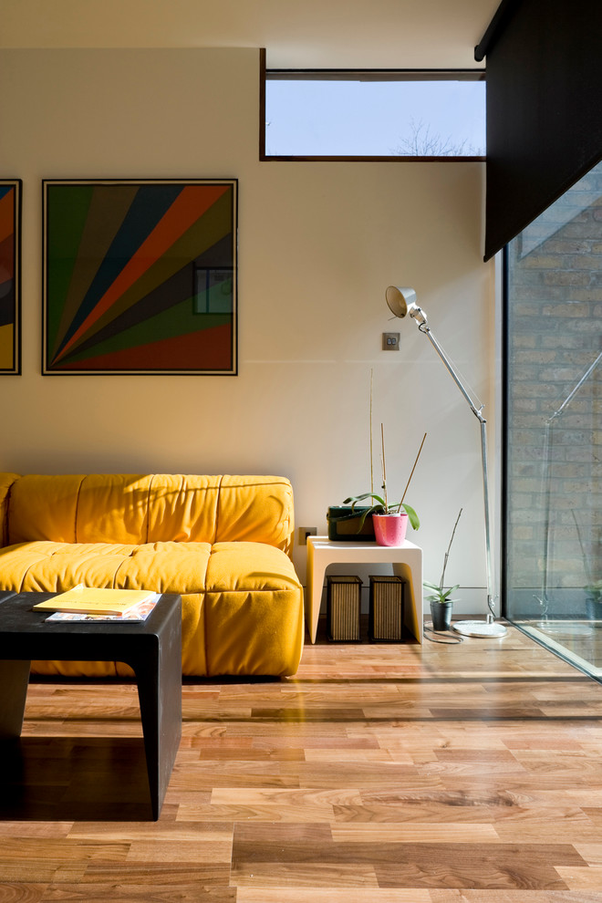 Cette image montre un salon design avec un mur beige.