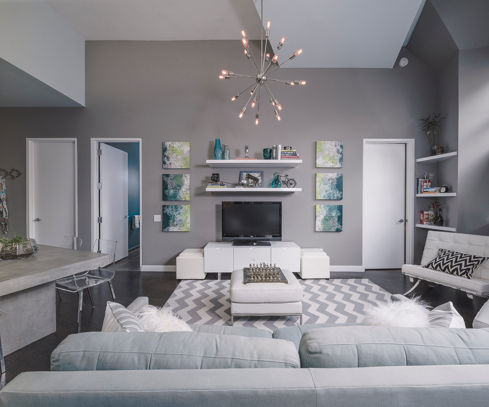 Offenes Modernes Wohnzimmer mit grauer Wandfarbe, dunklem Holzboden und freistehendem TV in New York