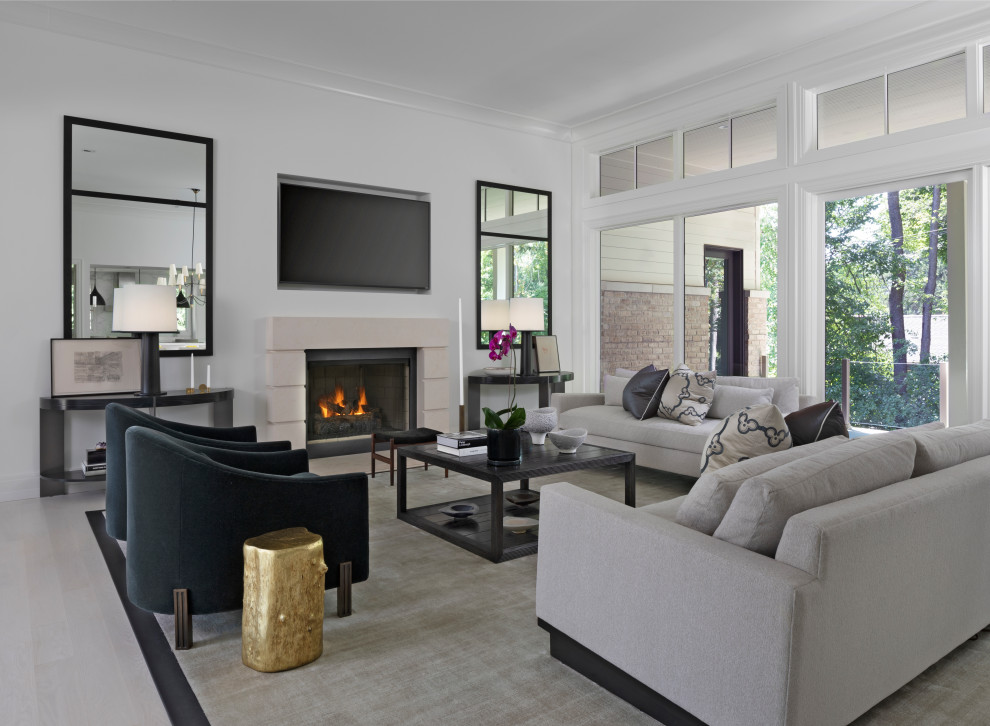 Foto di un soggiorno classico aperto con pareti bianche, parquet chiaro, camino classico, TV a parete e pavimento beige