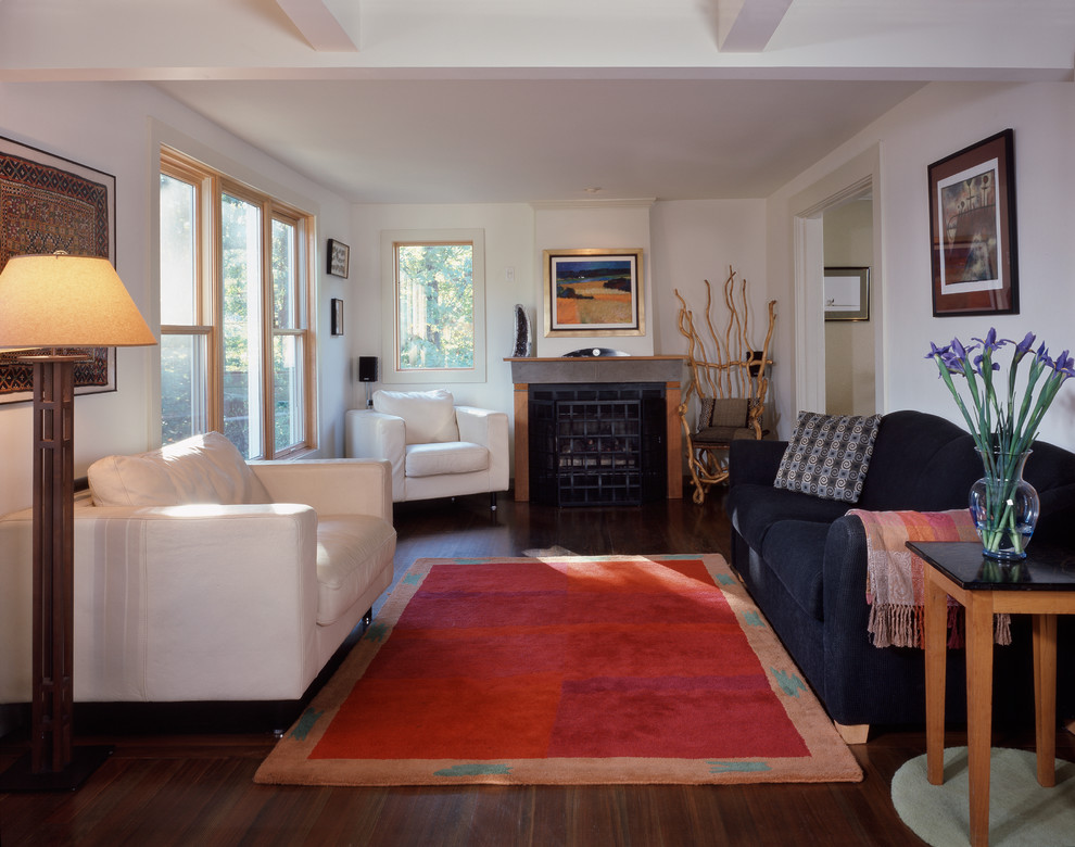 Offenes Klassisches Wohnzimmer mit weißer Wandfarbe, dunklem Holzboden, Kamin, Kaminumrandung aus Holz und braunem Boden in Seattle