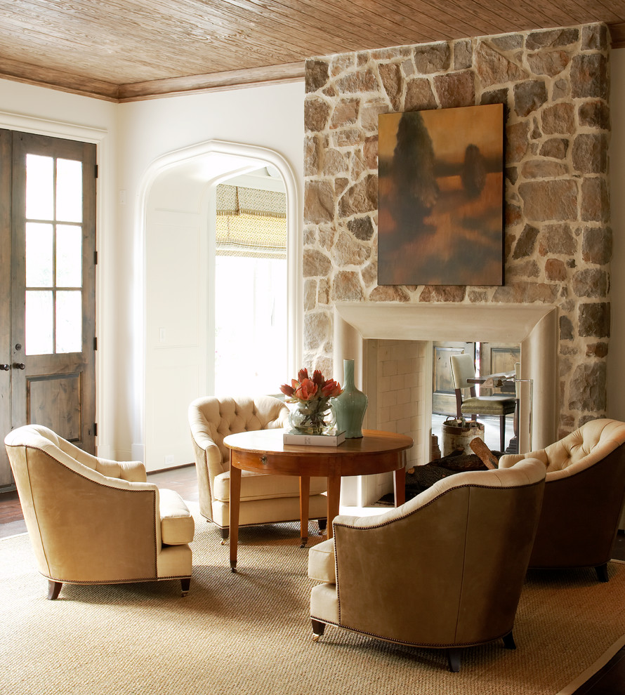 Foto de salón para visitas clásico sin televisor con paredes blancas, suelo de madera oscura, chimenea de doble cara y marco de chimenea de piedra