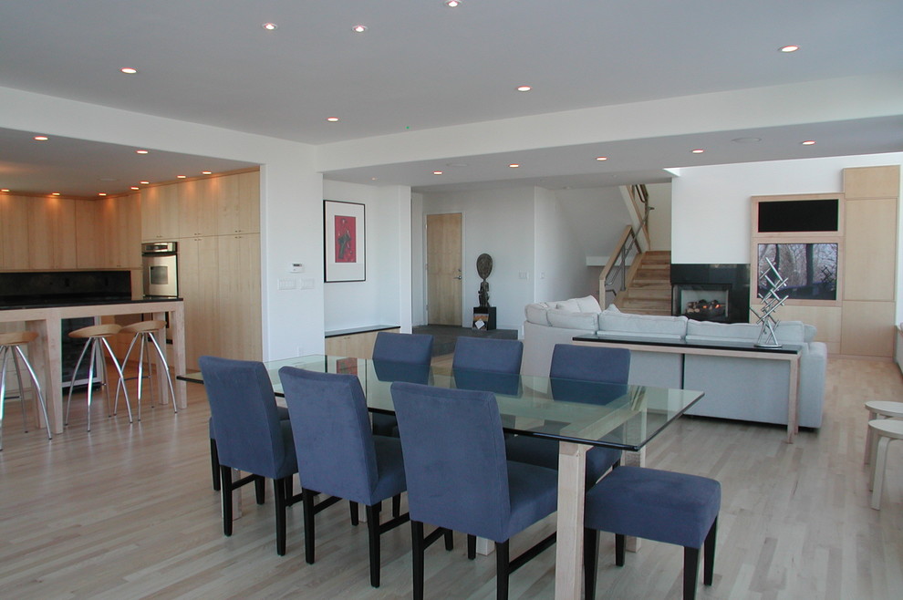 Cette image montre un salon minimaliste ouvert avec parquet clair, une cheminée d'angle, un manteau de cheminée en pierre et un téléviseur encastré.