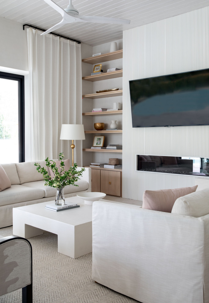 На фото: гостиная комната в стиле неоклассика (современная классика) с белыми стенами, горизонтальным камином, телевизором на стене и потолком из вагонки