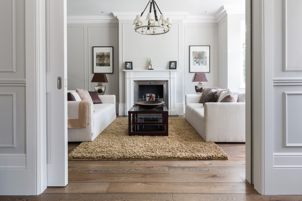 Repräsentatives, Fernseherloses, Abgetrenntes Klassisches Wohnzimmer mit grauer Wandfarbe, braunem Holzboden, Gaskamin, Kaminumrandung aus Holz und braunem Boden in London
