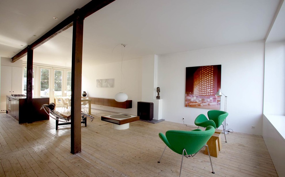 На фото: открытая гостиная комната среднего размера в современном стиле с белыми стенами, светлым паркетным полом и фасадом камина из металла без телевизора с
