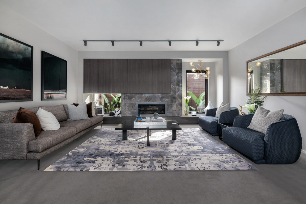 Cette image montre un salon design ouvert avec un mur gris, une cheminée ribbon, un manteau de cheminée en carrelage et un sol gris.