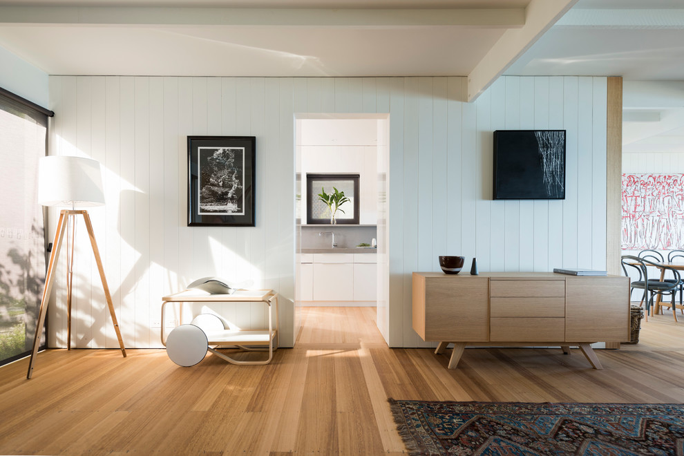 Diseño de salón abierto escandinavo de tamaño medio con paredes blancas y suelo de madera en tonos medios