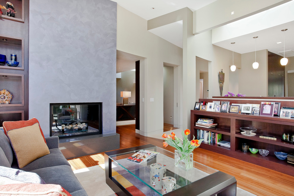 На фото: гостиная комната в стиле модернизм с двусторонним камином с