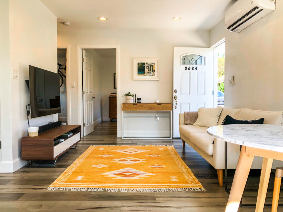 Kleines, Repräsentatives, Offenes Skandinavisches Wohnzimmer ohne Kamin mit braunem Holzboden, TV-Wand, braunem Boden und beiger Wandfarbe in Los Angeles