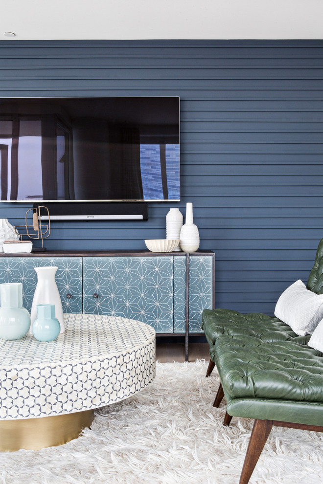Modelo de salón para visitas abierto vintage grande con paredes azules, suelo de madera clara, televisor colgado en la pared y suelo beige