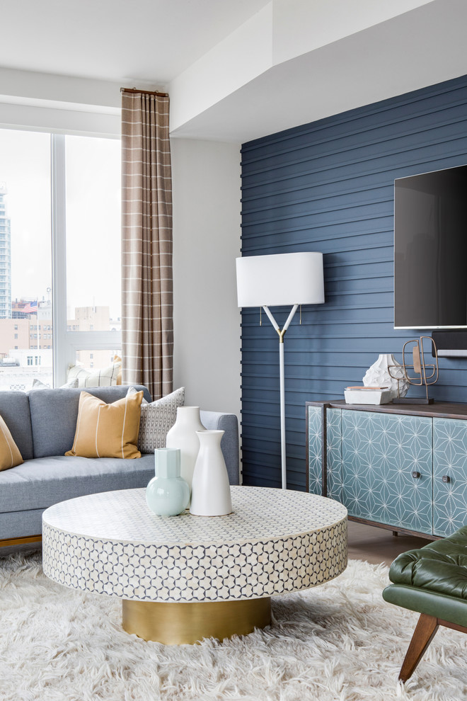 This is an example of a large midcentury formal open plan living room in Los Angeles with blue walls, light hardwood flooring, a wall mounted tv and beige floors.