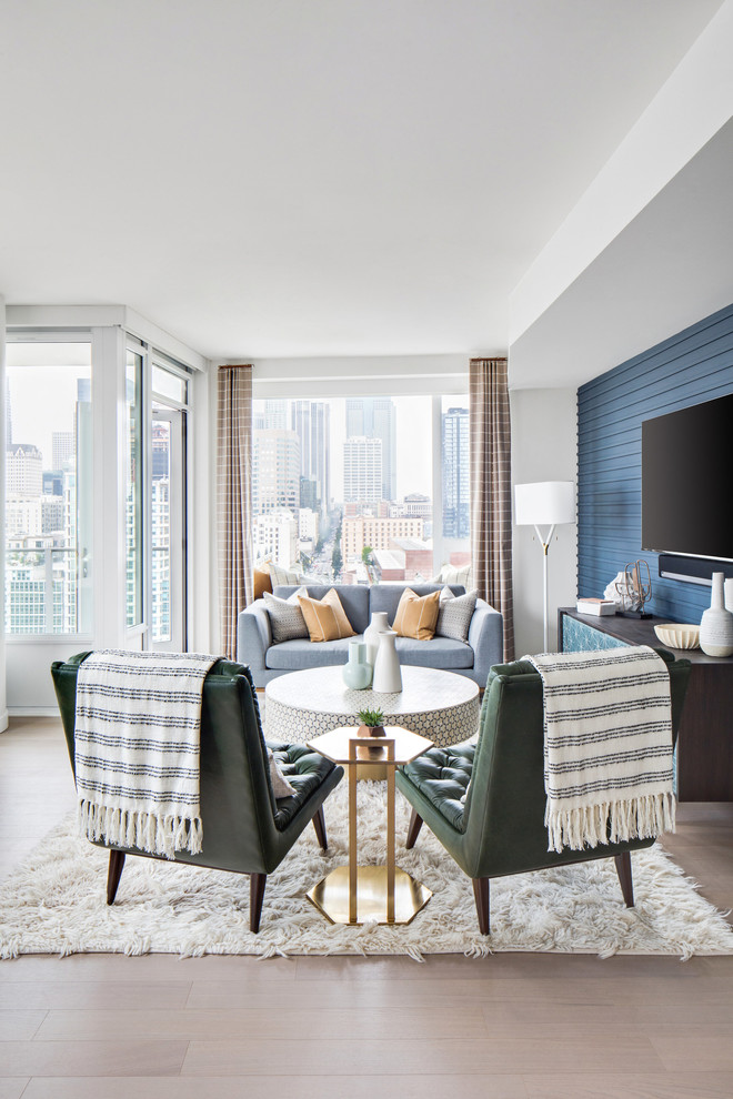 Imagen de salón para visitas abierto retro grande con paredes azules, suelo de madera clara, televisor colgado en la pared y suelo beige