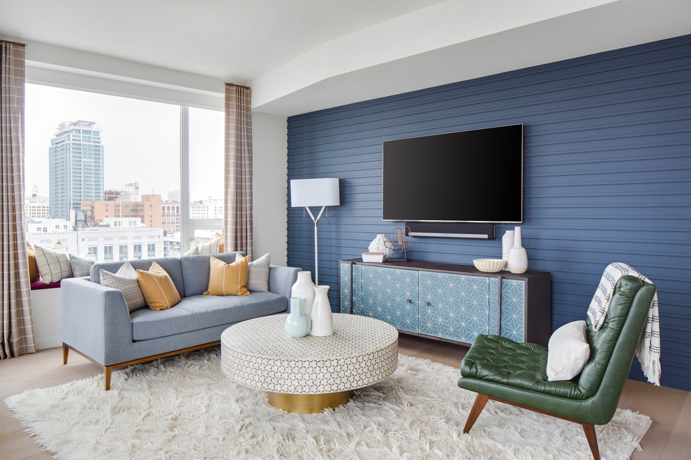 Aménagement d'un grand salon rétro ouvert avec un mur bleu, parquet clair, un sol beige, une salle de réception, un téléviseur fixé au mur et éclairage.
