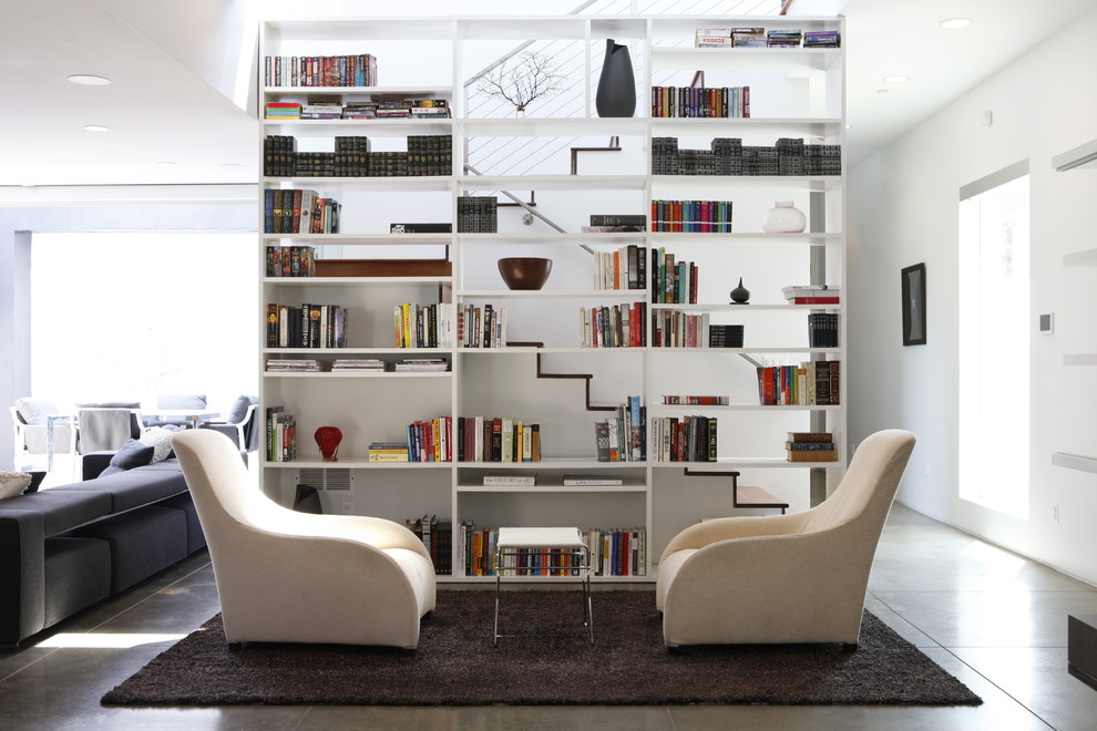 Cette photo montre un salon tendance ouvert avec un mur blanc, une bibliothèque ou un coin lecture et un escalier.