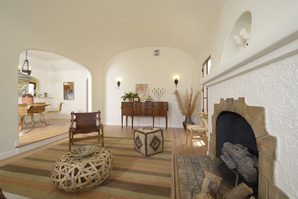 Идея дизайна: открытая, парадная гостиная комната среднего размера в средиземноморском стиле с белыми стенами, светлым паркетным полом, стандартным камином и фасадом камина из плитки