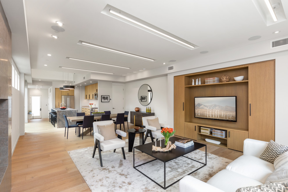 Esempio di un soggiorno design aperto con parquet chiaro, TV a parete, pavimento beige e pareti bianche