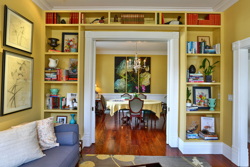 Idéer för mellanstora shabby chic-inspirerade separata vardagsrum, med ett bibliotek, gula väggar och mörkt trägolv