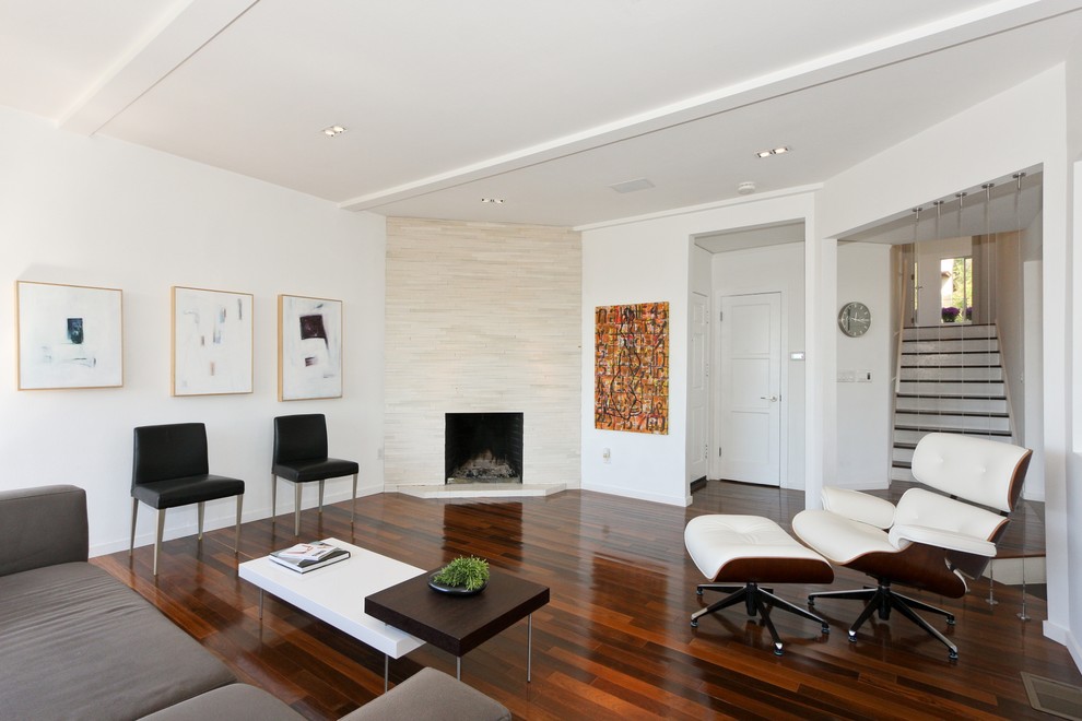 На фото: гостиная комната в современном стиле с угловым камином с