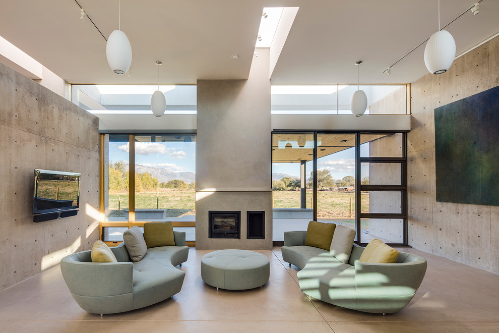 Modernes Wohnzimmer mit grauer Wandfarbe, Betonboden, Kaminumrandung aus Metall, Kamin und TV-Wand in Albuquerque