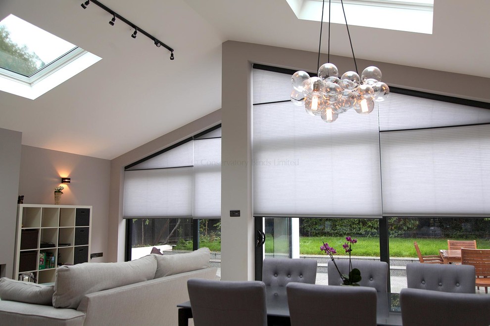 Großes, Repräsentatives, Fernseherloses Modernes Wohnzimmer ohne Kamin mit beiger Wandfarbe, hellem Holzboden und beigem Boden in Surrey