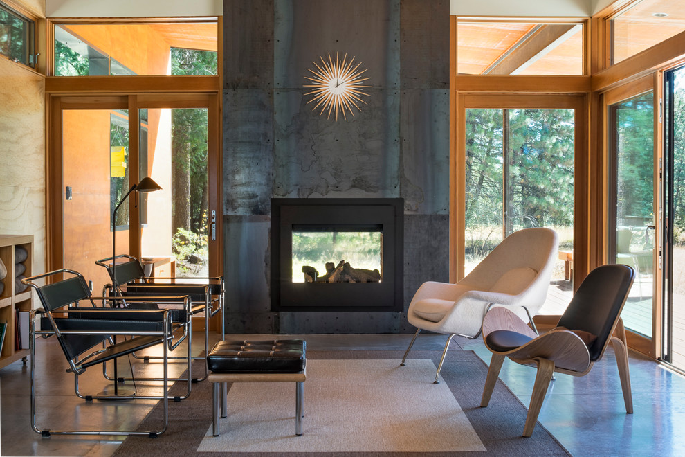 Mid-sized trendy enclosed concrete floor living room photo in Seattle with a two-sided fireplace, a metal fireplace and no tv