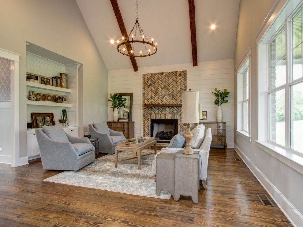 Inspiration for a medium sized classic open plan living room in Other with white walls, medium hardwood flooring, a standard fireplace, a brick fireplace surround and brown floors.