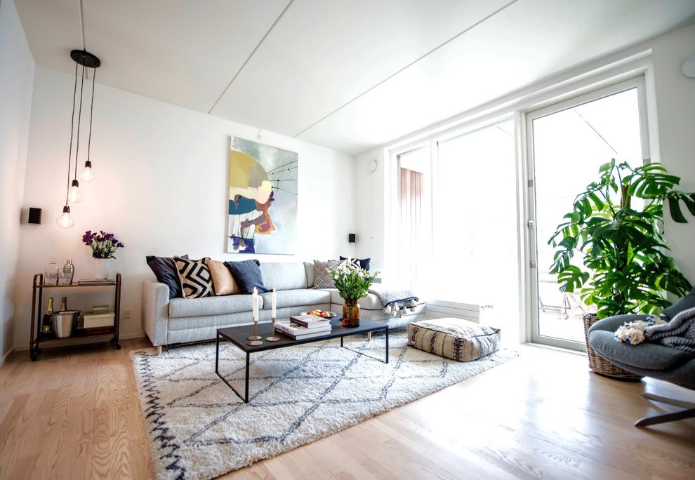 Skandinavisk inredning av ett mellanstort allrum med öppen planlösning, med en hemmabar, vita väggar, laminatgolv och en fristående TV