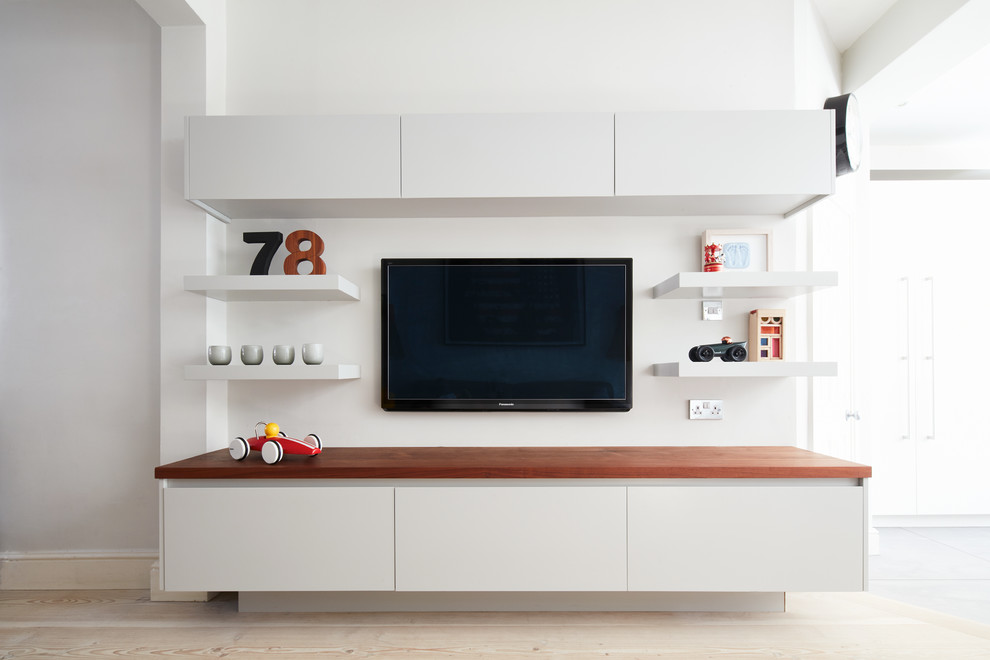 Ejemplo de salón abierto contemporáneo grande con paredes blancas, suelo de madera clara, televisor colgado en la pared y suelo beige