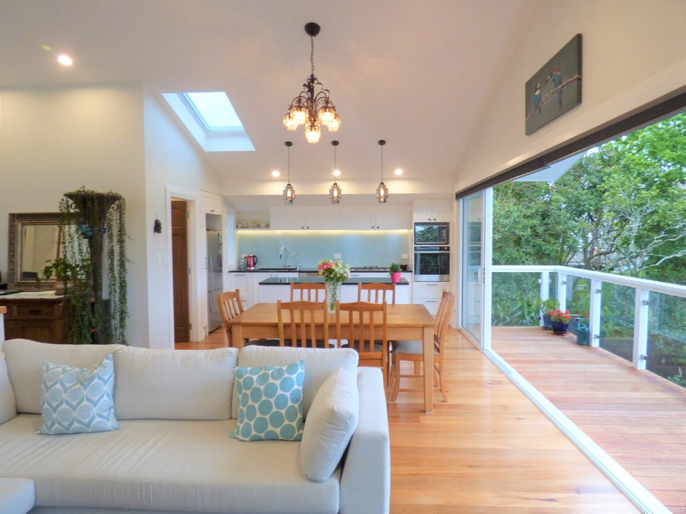 Photo of a large classic open plan living room in Auckland with medium hardwood flooring and brown floors.