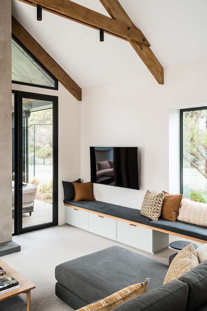Esempio di un soggiorno design di medie dimensioni e aperto con pareti bianche, moquette, TV a parete e pavimento beige