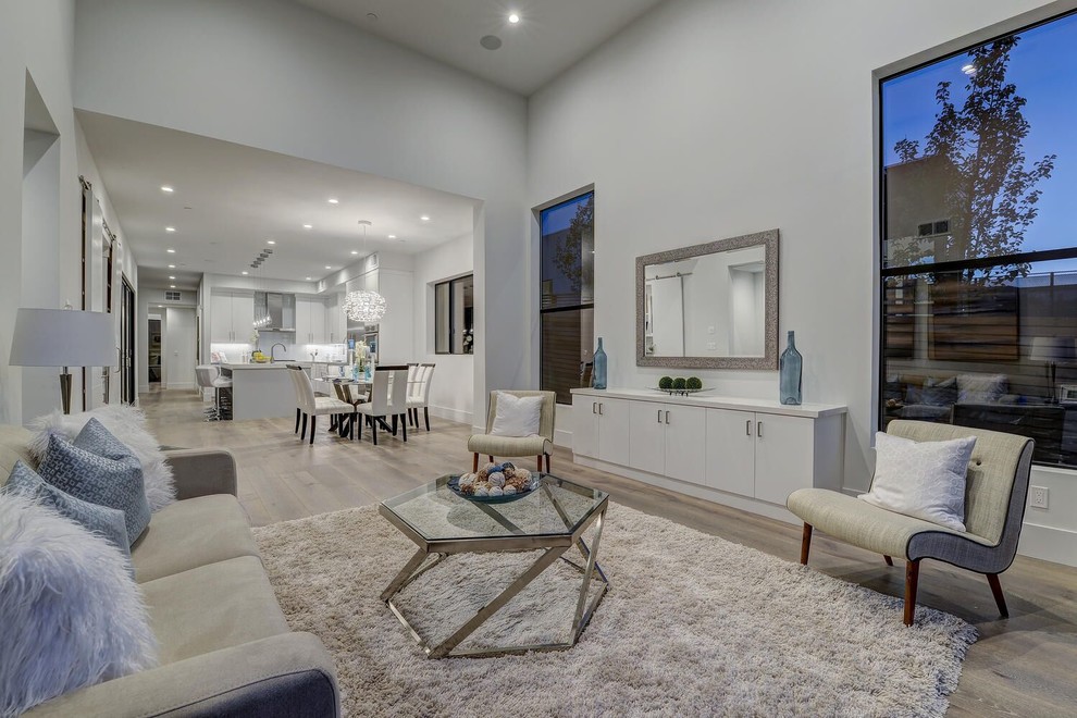 Foto di un soggiorno minimal di medie dimensioni e aperto con sala formale, pareti bianche, parquet chiaro e pavimento beige