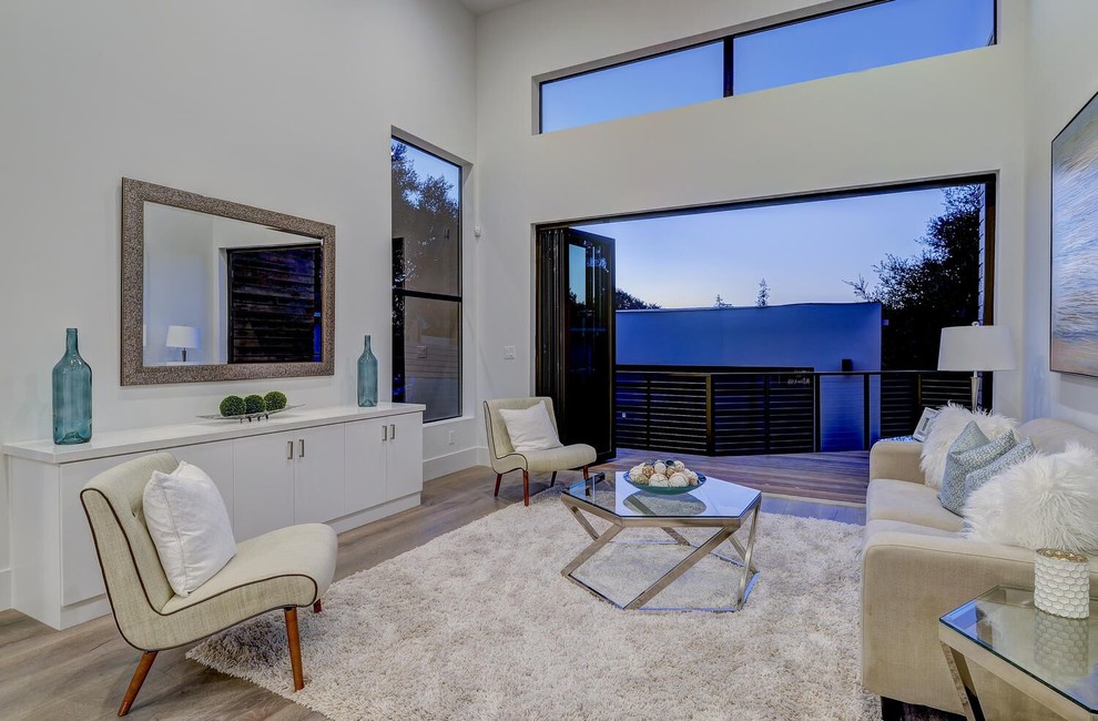 Immagine di un soggiorno minimal di medie dimensioni e aperto con sala formale, pareti bianche, parquet chiaro e pavimento beige