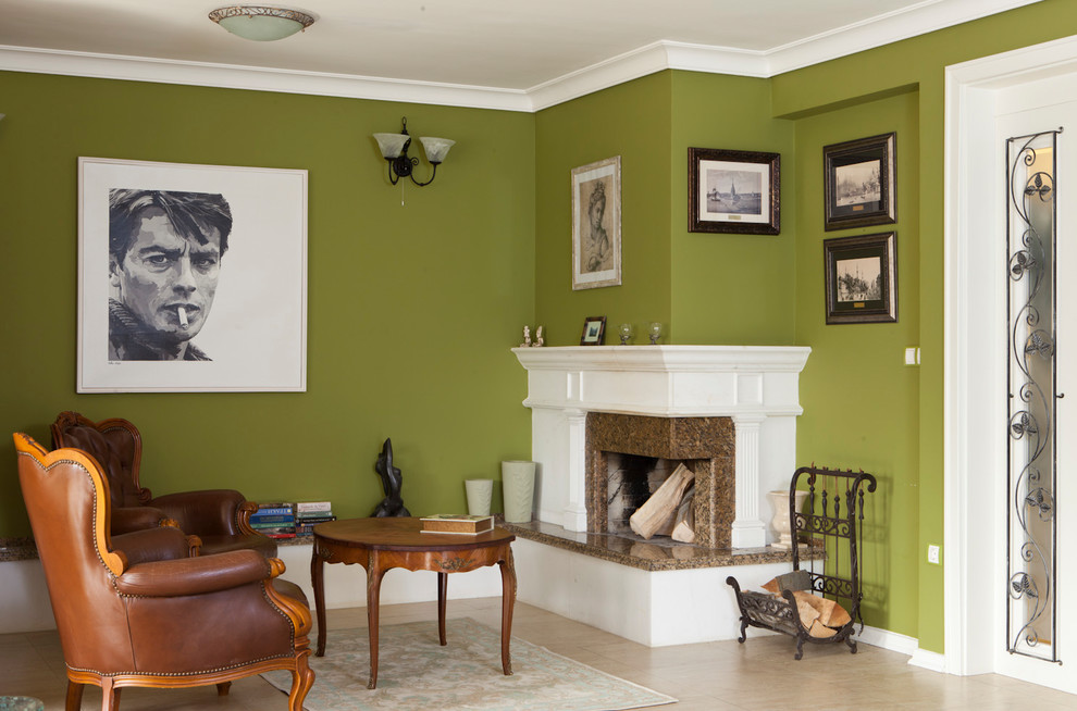 На фото: большая гостиная комната в стиле кантри с зелеными стенами, полом из терракотовой плитки, угловым камином, фасадом камина из камня и отдельно стоящим телевизором