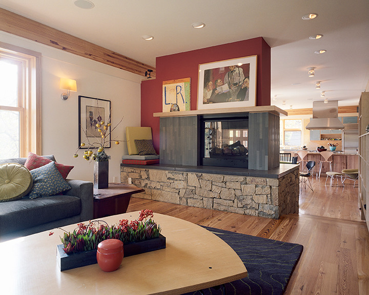 Offenes Klassisches Wohnzimmer mit roter Wandfarbe, hellem Holzboden, Tunnelkamin und gefliester Kaminumrandung in Kansas City